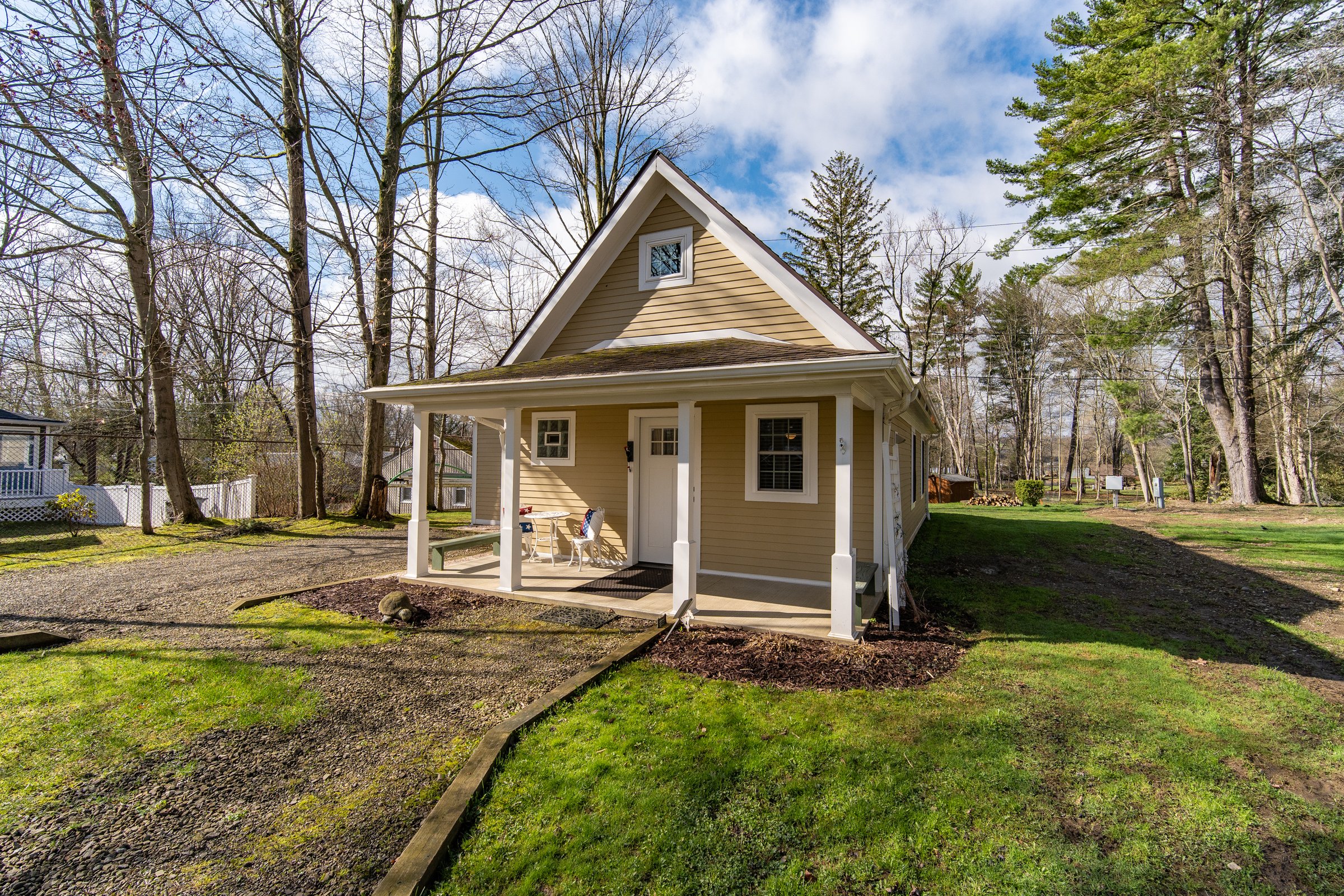 The Cottage at The Woods, a small gabled cottage with white trim